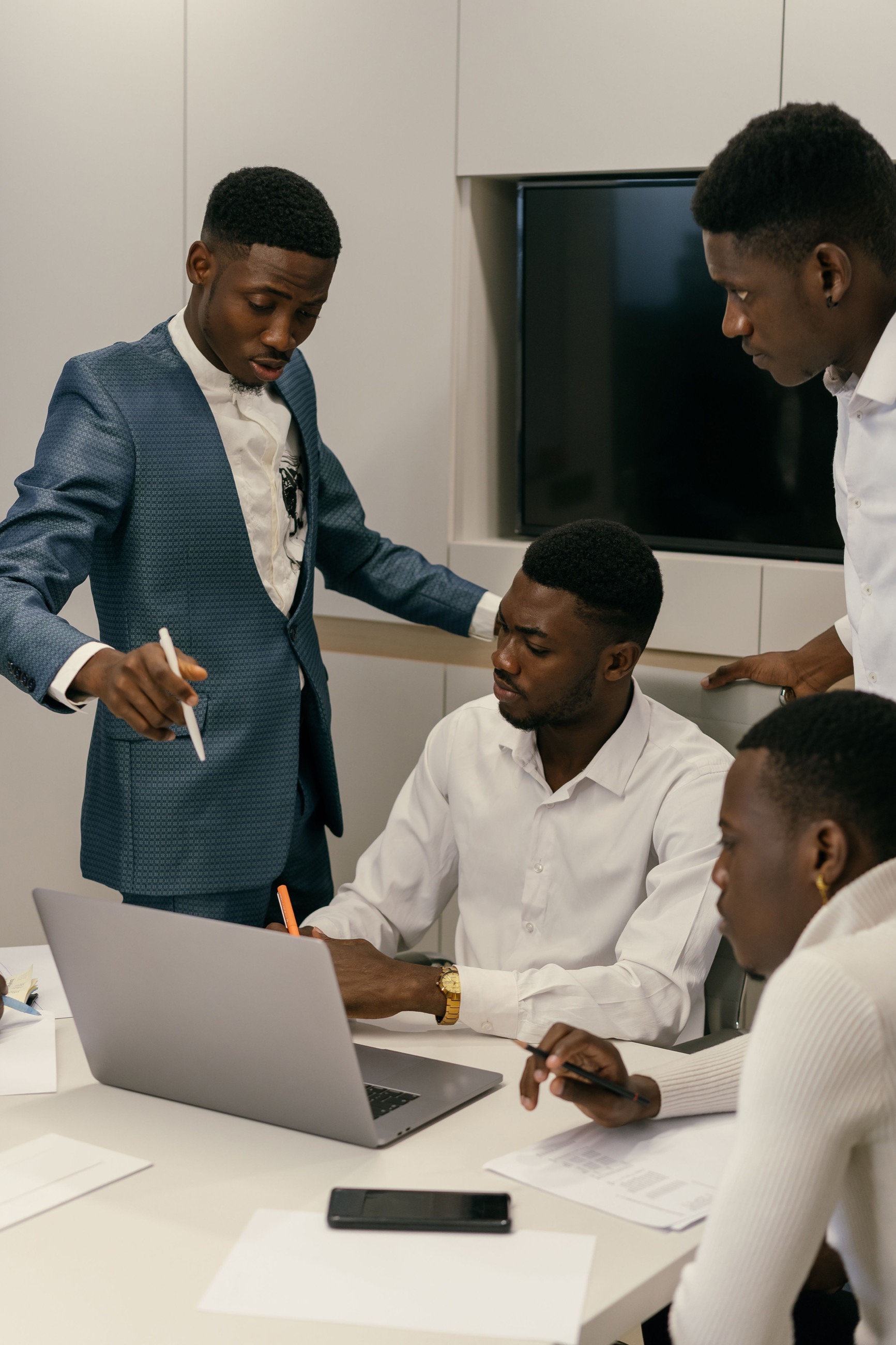 A professional African team working together around a laptop.